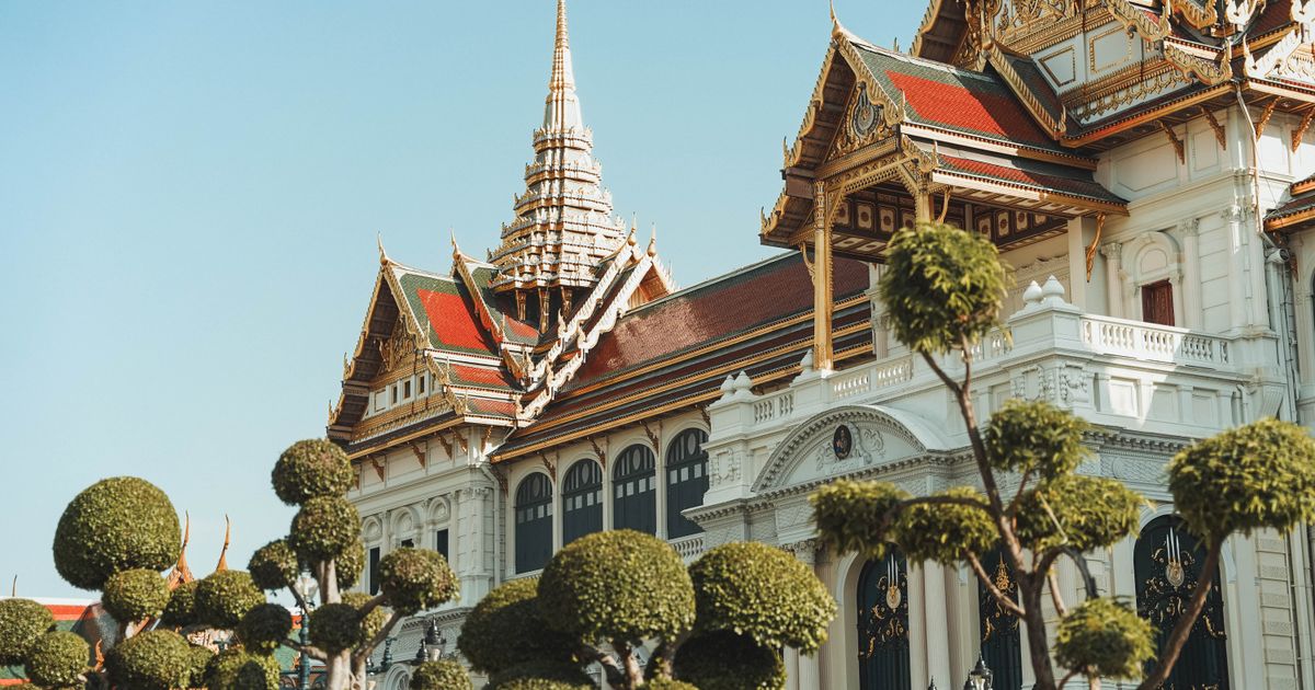 Grand Palace ornate architecture with trimmed trees, Bangkok